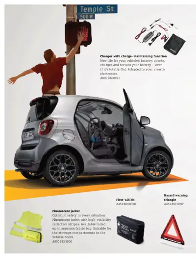 Smart ForTwo with open door showing four safety and maintenance accessories with part numbers.